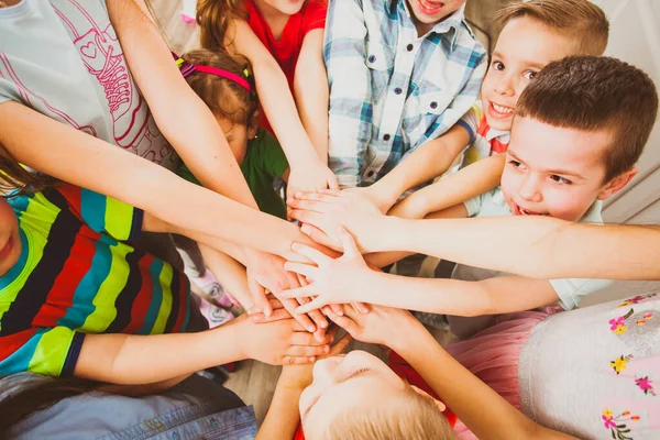 Niños pequeños poniendo sus manos juntas al aire libre. Unidad, trabajo en equipo, concepto de amistad — Foto de Stock