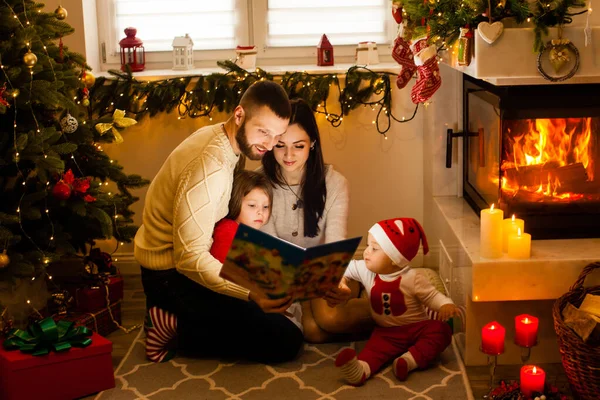 Glad familj läser julsagor. Julfamiljetraditioner — Stockfoto