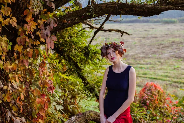 Sinnliche Frau über dem herbstlichen Baum mit Kranz — Stockfoto