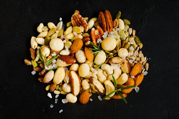 Zdravé svačinka, sortiment různých ořechů na černém pozadí — Stock fotografie