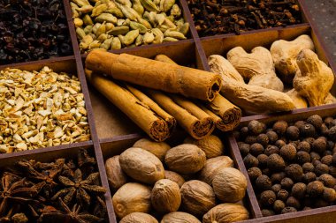 Tahta kutunun üzerinde çeşitli otlar ve baharatlar var.
