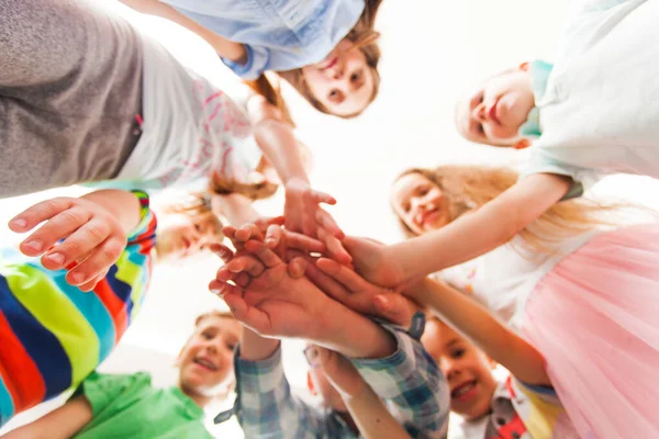 Un grupo de niños junta sus manos. Concepto de trabajo en equipo —  Fotos de Stock