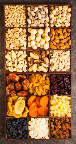 Muitas nozes de variedade e frutas secas em uma caixa de madeira, flat lay, vista superior — Fotografia de Stock