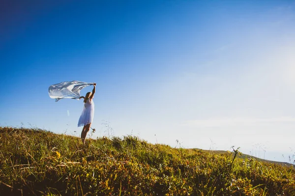 Kobieta ucieka ciesząc się słońcem na szczycie góry. — Zdjęcie stockowe