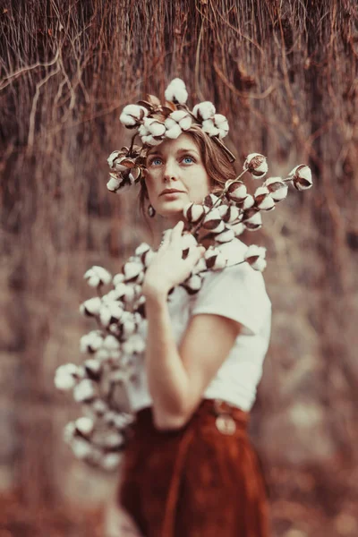 Menina incrível com olhos azuis, tendo penteado de moda com flores de algodão . — Fotografia de Stock