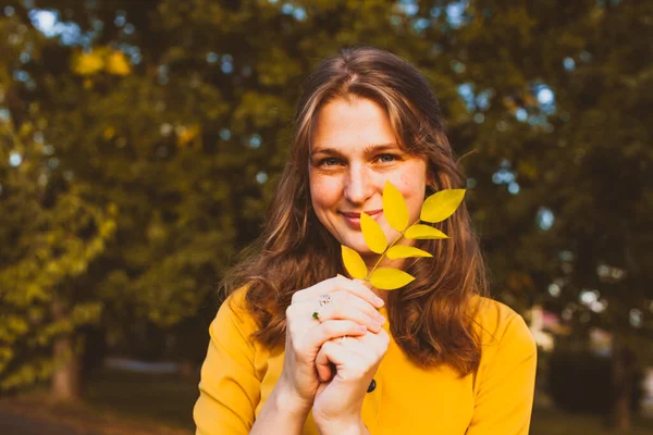 Porträt einer fröhlichen jungen Frau mit Herbstblatt — Stockfoto