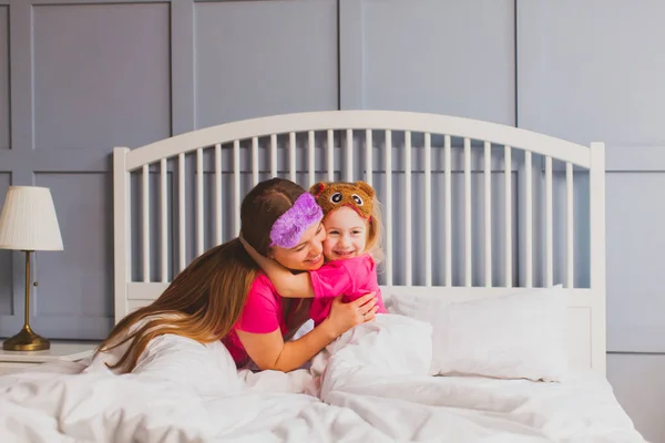 Abraços gentis de mãe e filha depois de acordar — Fotografia de Stock