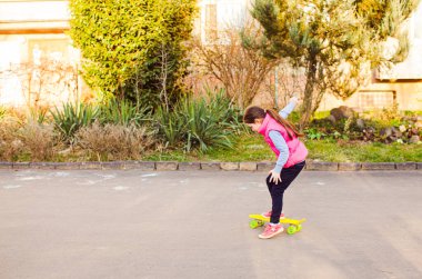 Kaykaycı kız sarı panoda antrenman yapıyor.
