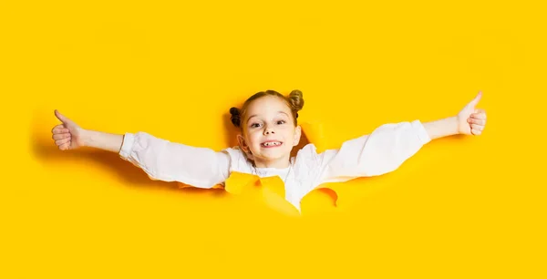 Schoolmeisje bevrijdt zichzelf van geel papier — Stockfoto