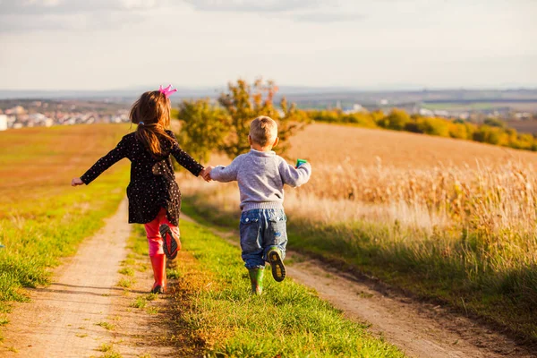 Kids have fun are running on country road — Stock Photo, Image