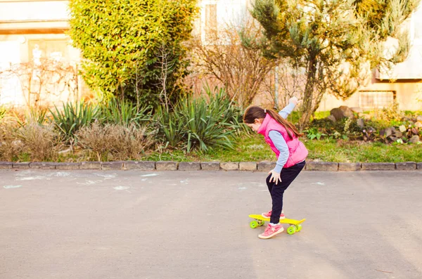 Skateboarder meisje training buiten op geel penny board — Stockfoto