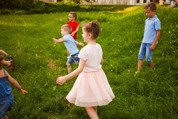 Crianças brincando com bolhas de sabão no parque — Fotografia de Stock