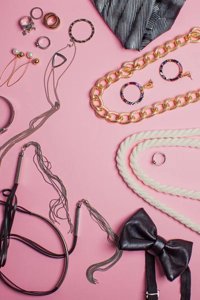 Stylisches Schmuck- und Haar-Accessoire-Objekt. Modeaccessoires auf rosa Hintergrund, Ansicht von oben. — Stockfoto