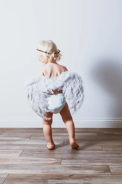 Rückseite Blondes Kleinkind mit weißen Flügeln — Stockfoto
