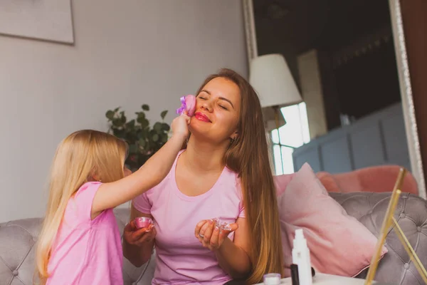 Mother enjoying beauty procedures made by her daughter