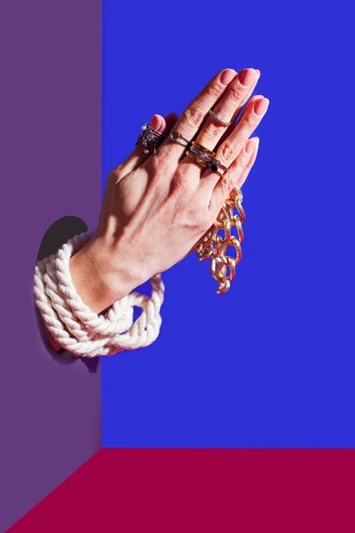 Mãos femininas dobradas em um gesto de oração, colando de uma parede — Fotografia de Stock