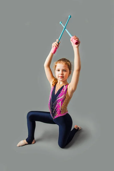 Gelukkig gymnastiek meisje in een kostuum, holding sticks — Stockfoto