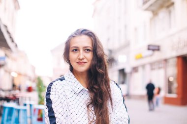 Kadın küçük bir Avrupa şehrinin merkezinde yürüyor.