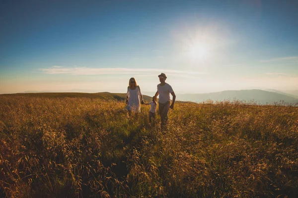 Familie spaziert auf einem Feld mit wildem Weizen — Stockfoto