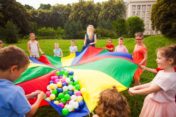 Stäng visa färgglada fallskärm med bollar. Barn i cirkel — Stockfoto