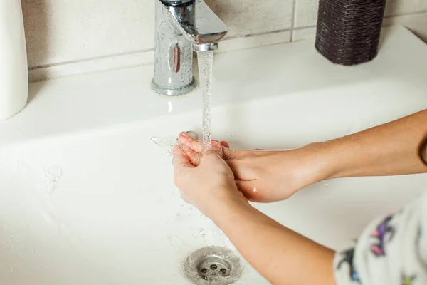 Руки крупным планом девушки во время мытья с проточной водой — стоковое фото