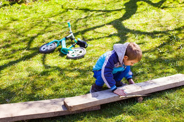 Anak kecil membangun jalan kayu di halaman belakang — Stok Foto