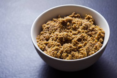 Zemin zeytin, koyu gri yüzeyde kaseye yayılmış.