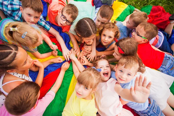 Niños tendidos juntos en círculo en tierra colorida — Foto de Stock