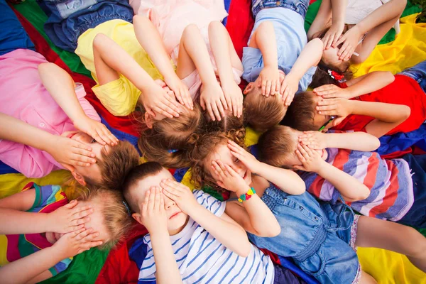 Children laying very closely, covering face by hands — Stock Photo, Image