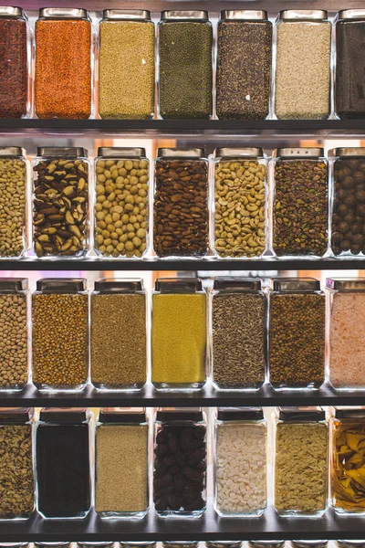 Grande seleção de cereais, nozes e frutas secas em uma loja de alimentos saudáveis — Fotografia de Stock