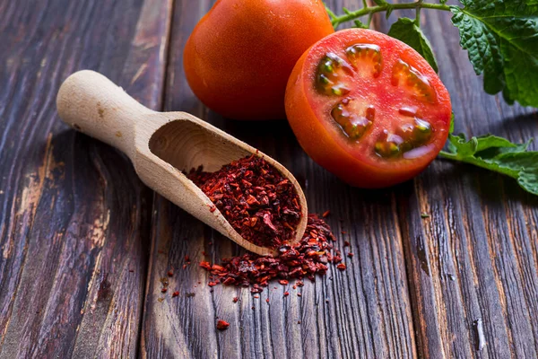 Holzlöffel mit Tomatenpulver auf Holzoberfläche — Stockfoto