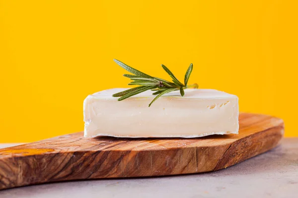 Stuk camembert kaas, close-up op gele achtergrond — Stockfoto