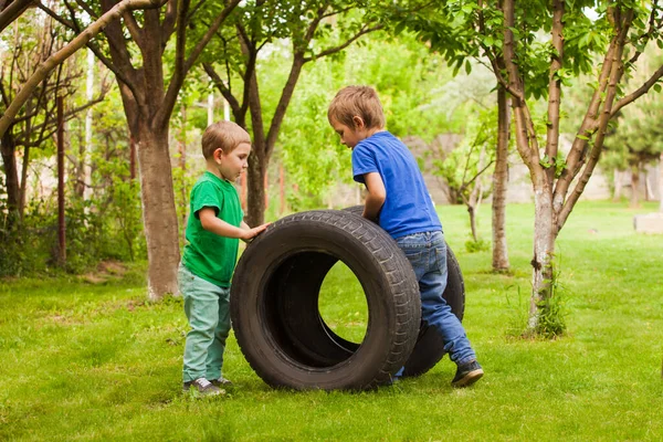 Los niños pequeños están interesados en neumáticos de coche — Foto de Stock