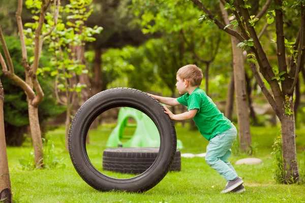 El niño raptó los neumáticos del coche de los papás — Foto de Stock