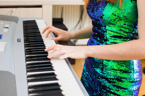 The young woman is playing in the studio on a synthesizer — Stock Photo, Image