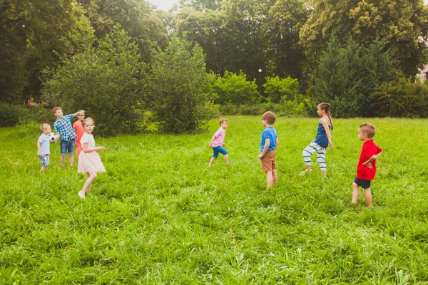 Los niños se divierten y practican deportes con una pelota — Foto de Stock