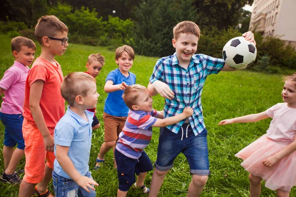 The big boy does not want to share the ball with small children — Stock Photo, Image