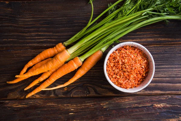 Vista superior manojo de zanahorias con condimento en tazón —  Fotos de Stock