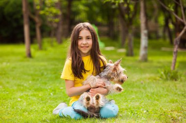 Bahçede küçük bir köpekle dinlenen kız.