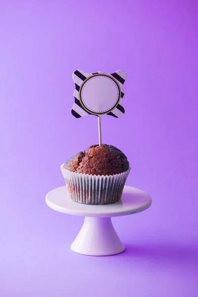 Cupcake au chocolat avec étiquette topper vide, fond violet — Photo