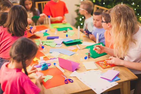 Maestra con sus hijos mientras el taller de tarjetas de Navidad — Foto de Stock