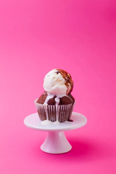 Schmelzendes Eis auf dem Schokoladenmuffin in rosa — Stockfoto