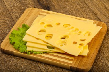 Ahşap arka plan üzerinde dilimlenmiş peynir salata yaprakları