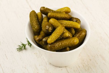 Ahşap arka plan üzerinde kaseye Picled salatalık