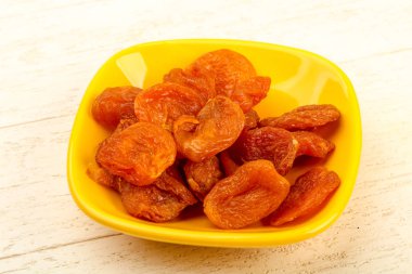 Kuru Kayısı yığın içinde kase ahşap arka plan üzerinde