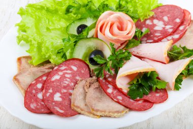 Et ve sosis salata yaprakları ve maydanoz ile karıştırın
