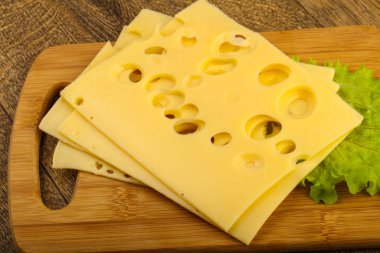 Dilimlenmiş peynir salata ile ahşap tahta üzerinde yapraklar