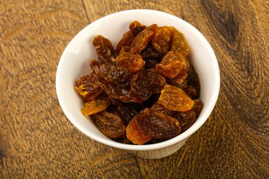 Ahşap arka plan üzerinde kase kuru kuru üzüm