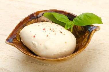 Fesleğenli mozzarella peyniri tahta masada bırakır