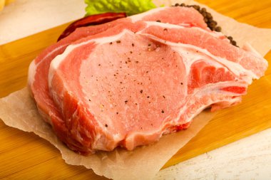 Biber ve tuz ahşap tahta üzerinde yemek pişirmek için hazır Çiğ domuz pirzola